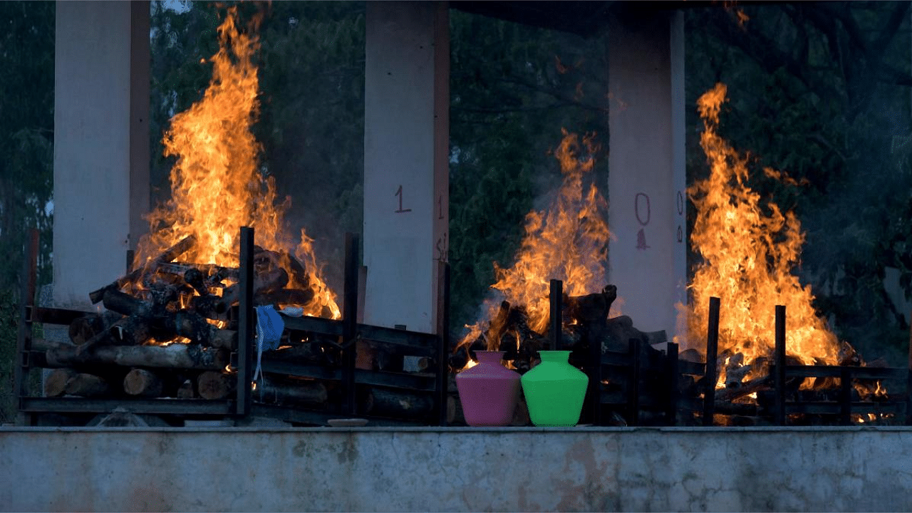 Burning pyres of victims who lost their lives due to the Covid-19 are seen at an open crematorium in Bangalore. Credit: AFP photo.