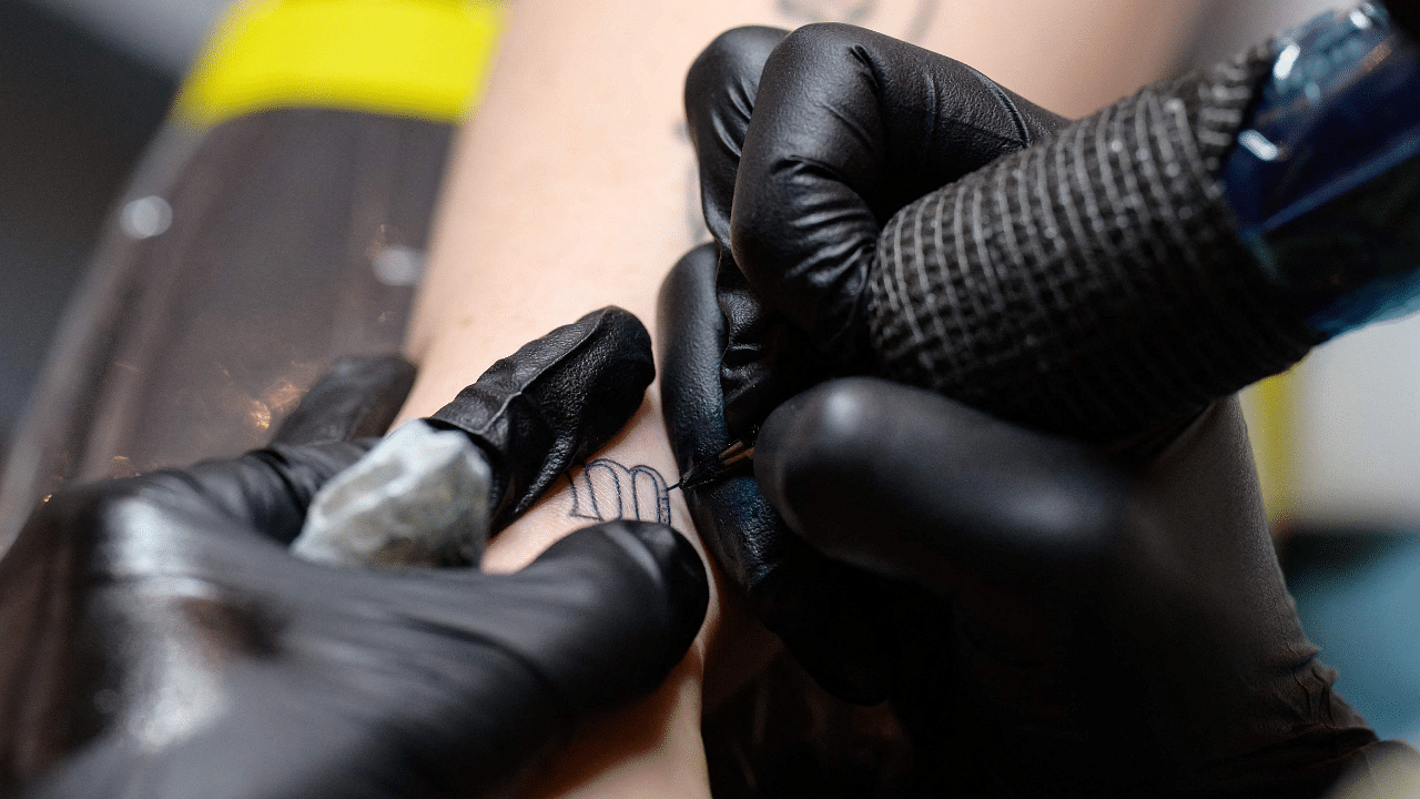 Abigail Glasgow receives a temporary tattoo by tattoo artist Marissa Boulay at Ephemeral tattoo shop. Credit: AFP Photo