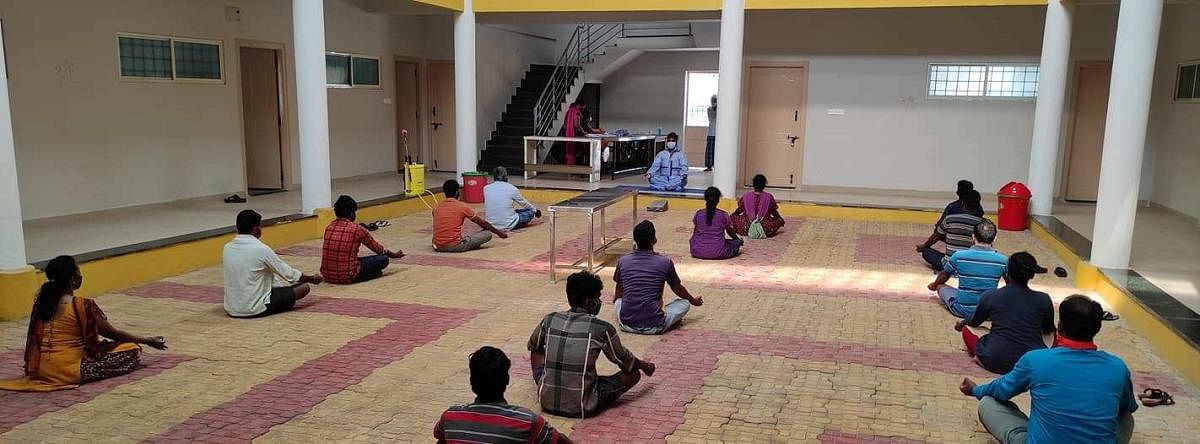 Allama Prabhu teaches yoga to patients at a Covid Care Centre in KR Pet, Mandya district. DH Photo