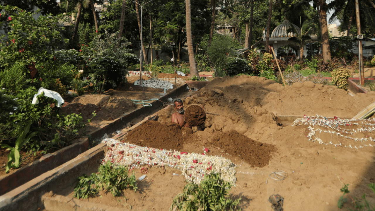 An assistant of Sayyed Munir Kamruddin, a gravedigger, prepares a grave for coronavirus disease burials at a graveyard in Mumbai. Credit: Reuters Photo