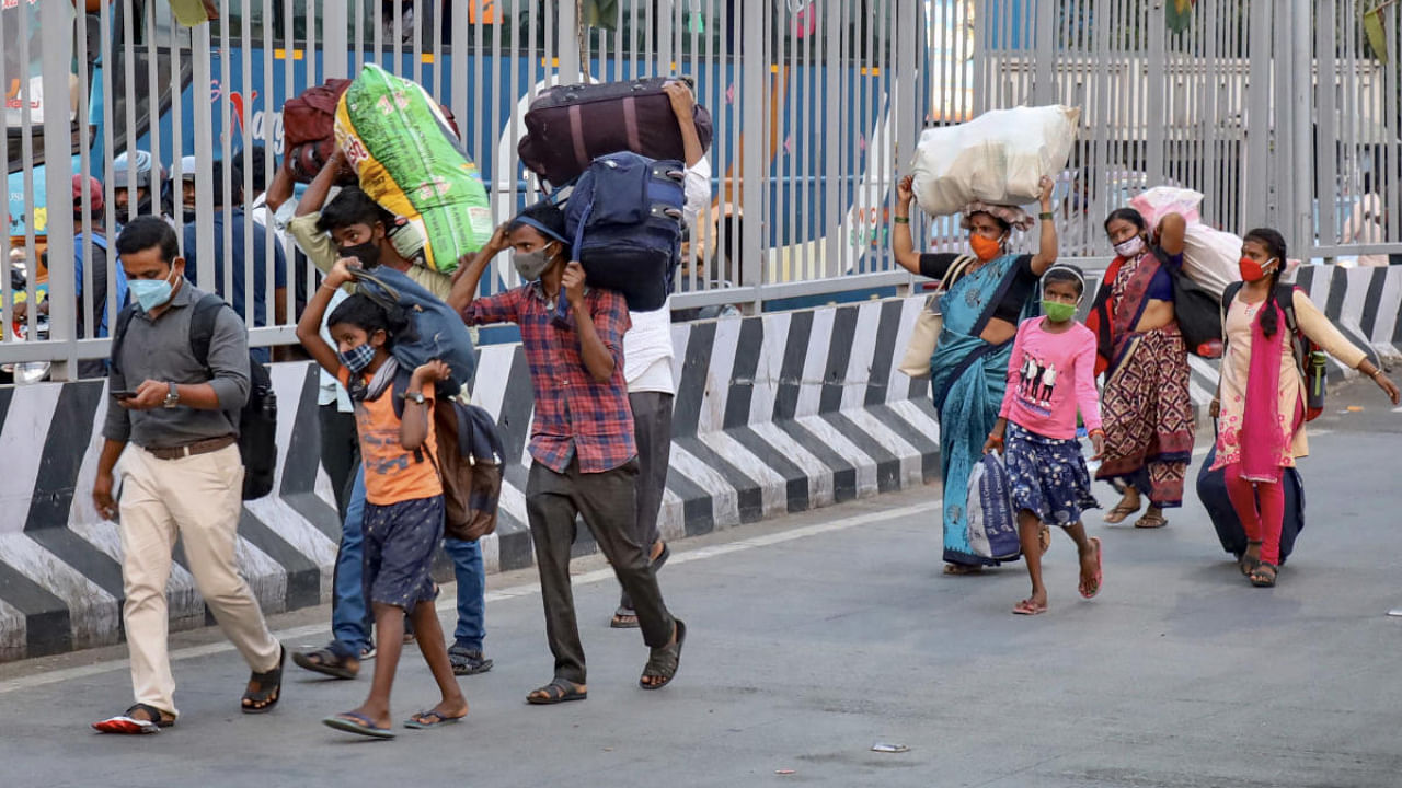 Migrants leave for their home states amid coronavirus second wave of the pandemic at Kempegowda bus station, Majestic in Bengaluru. Credit: PTI photo.