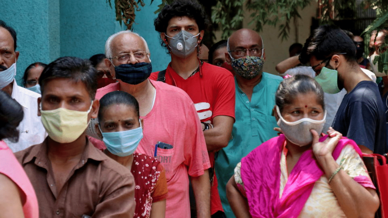 People wearing protective face masks wait to receive a vaccine against the coronavirus disease (COVID-19) at a vaccination centre in Mumbai, India, April 28, 2021. Credit: Reuters File Photo