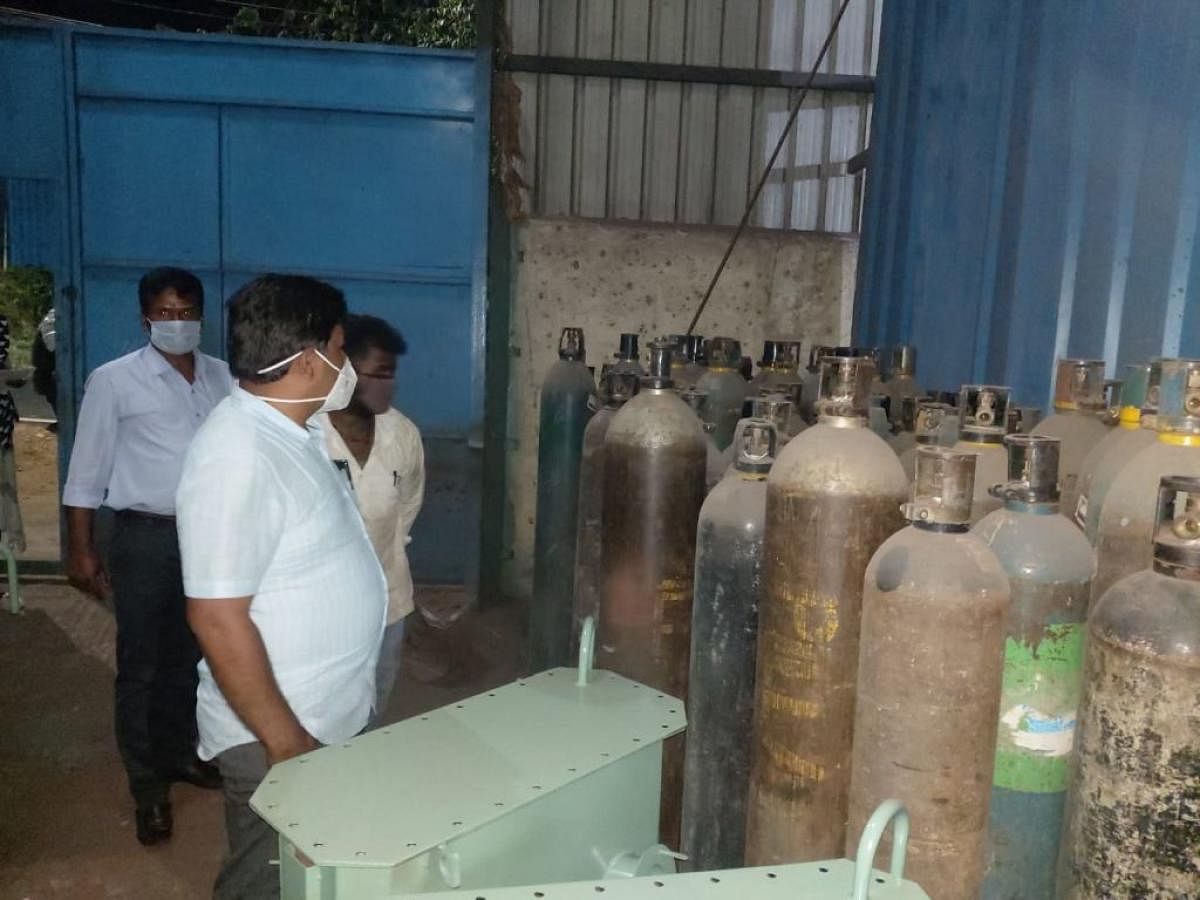 Tahsildar Chandrashekar conducts a raid at Tubinakere Industrial area in Mandya taluk, on Thursday, when oxygen cylinders were seized. DH Photo