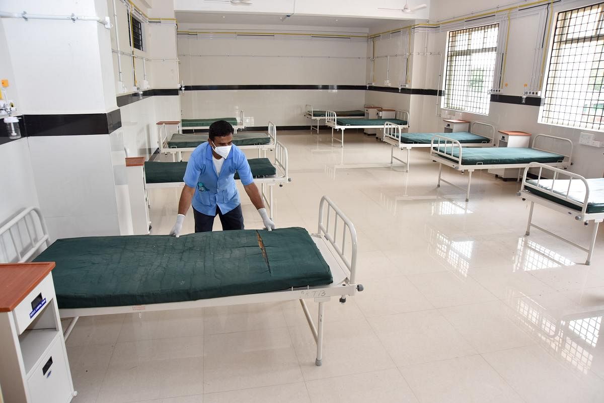 A hospital staffer prepares beds at the Trauma Care Centre on PKTB Sanatorium premises in Mysuru. DH FILE Photo