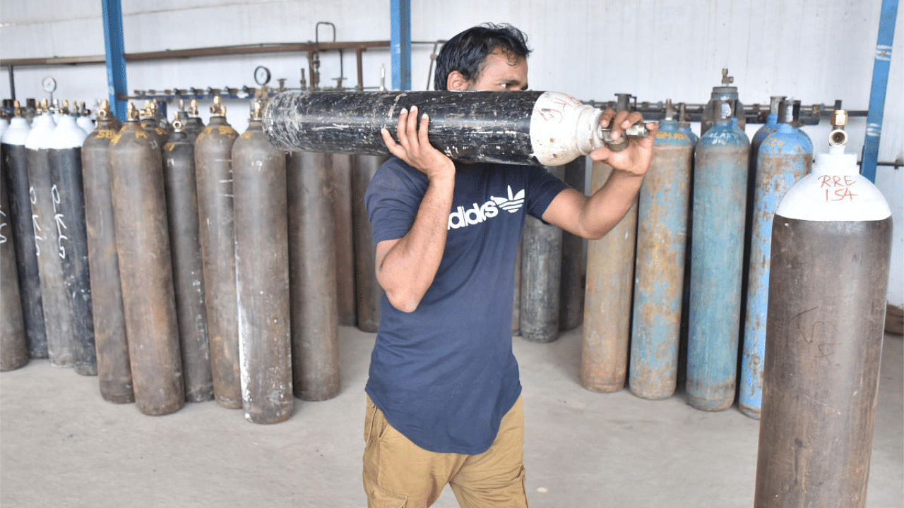 Staff refilling oxygen at the Unity Gas Company at Karithimma Halli near Kasturbha Nagar in Bengaluru. Credit: DH Photo