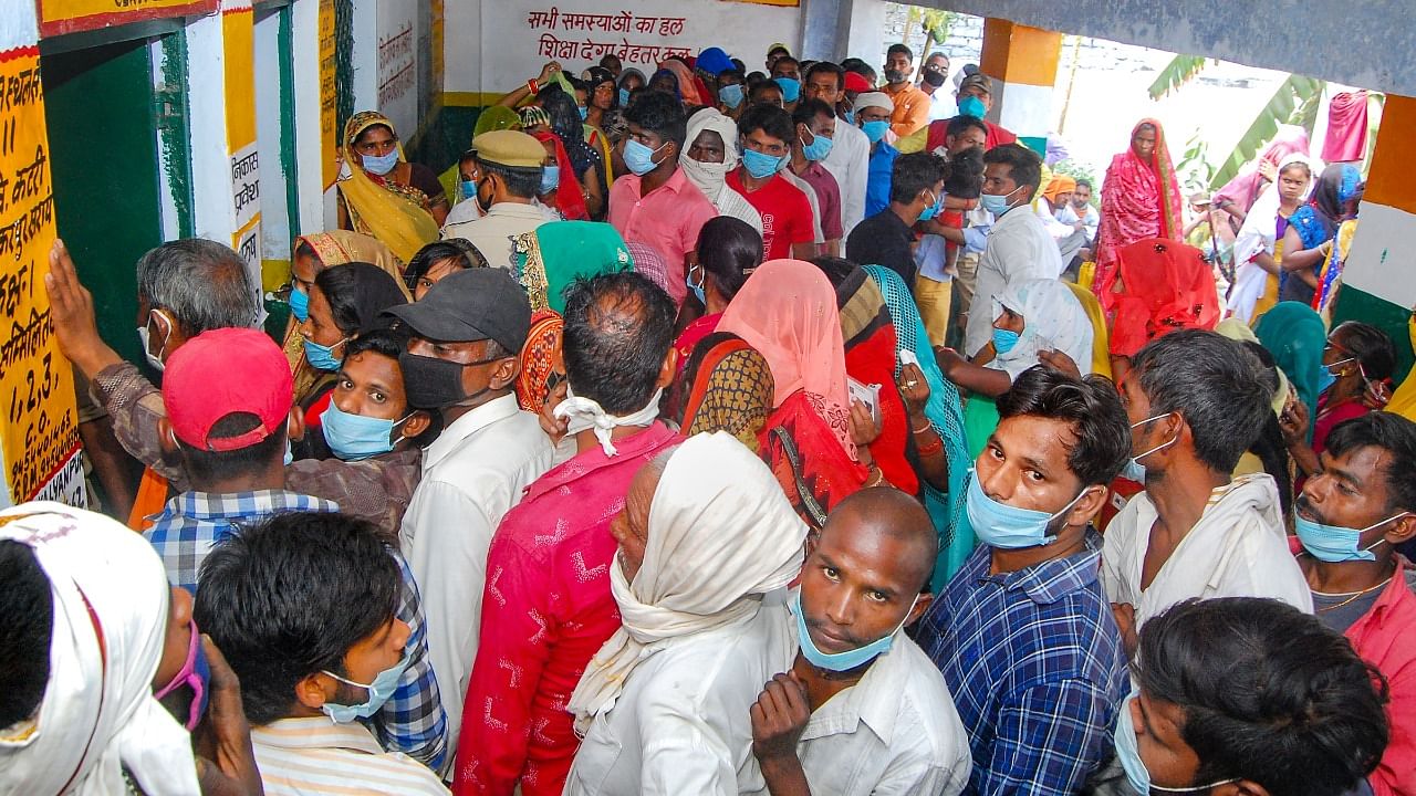 People, ignoring social distancing norms, wait to cast votes for Panchayat elections, at Shankarpur Sarai Katri in Kanpur. Credit: PTI Photo
