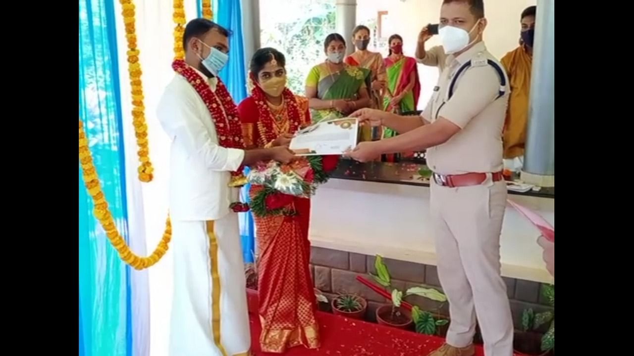 Kozhikode rural district police chief A Srinivas handing over certificate of appreciation to newly-wed couple Linto and Kavya.