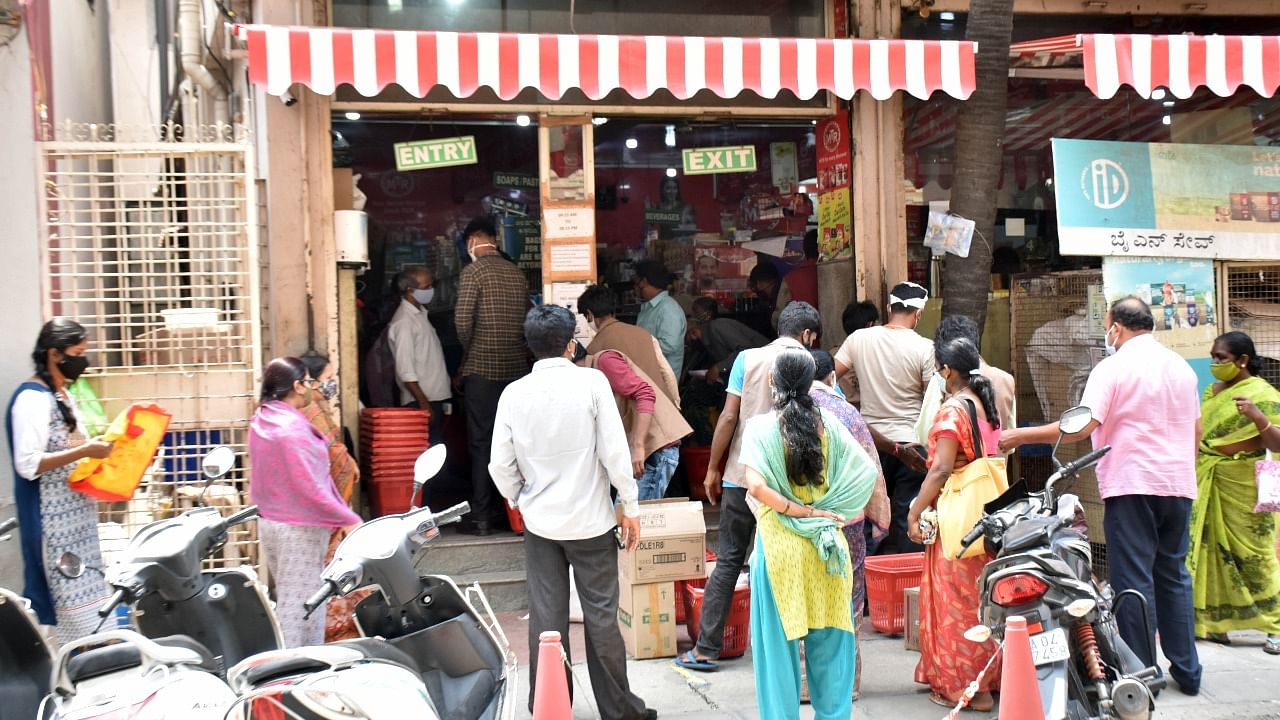 People wait in a queue outside a grocery store in Bengaluru during the 14-day-long Karnataka lockdown. Credit: DH Photo/Janardhan B K