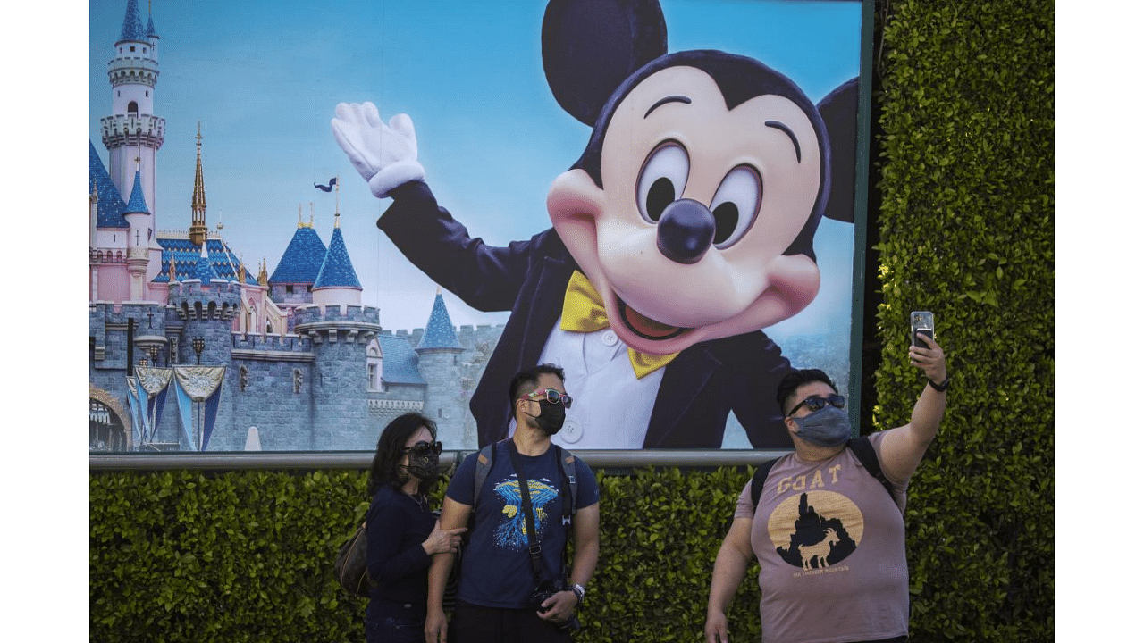 People pose for selfies at Disneyland Park as it reopens for the first time since the COVID 19 pandemic forced the park to shut down last year on April 30, 2021 in Anaheim, California.  Credit: AFP Photo