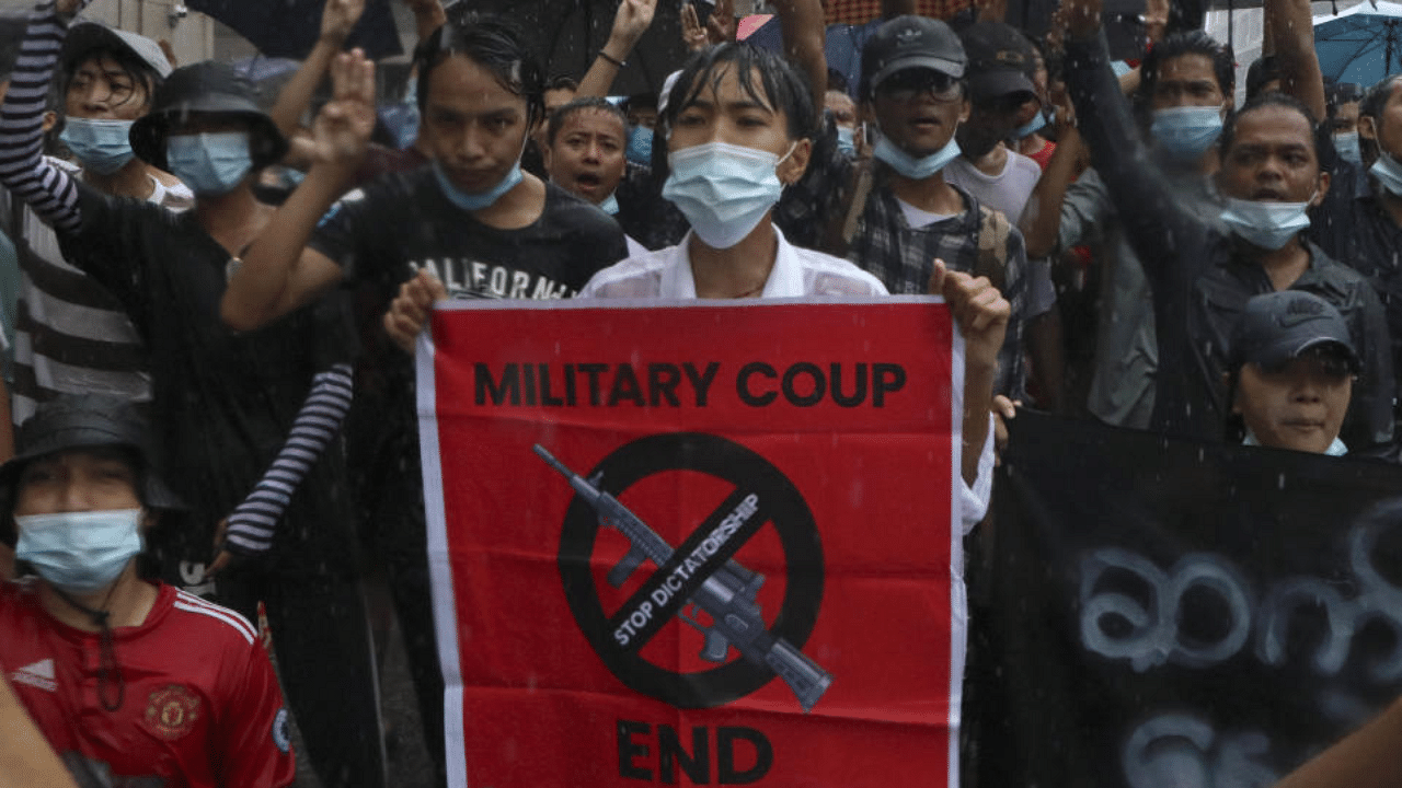 Anti-coup protesters flash the three-finger salute and chant slogan during the demonstration against the military coup in the rain at Pabedan township in Yangon, Myanmar, Friday, April 30, 2021. Credit: AP Photo