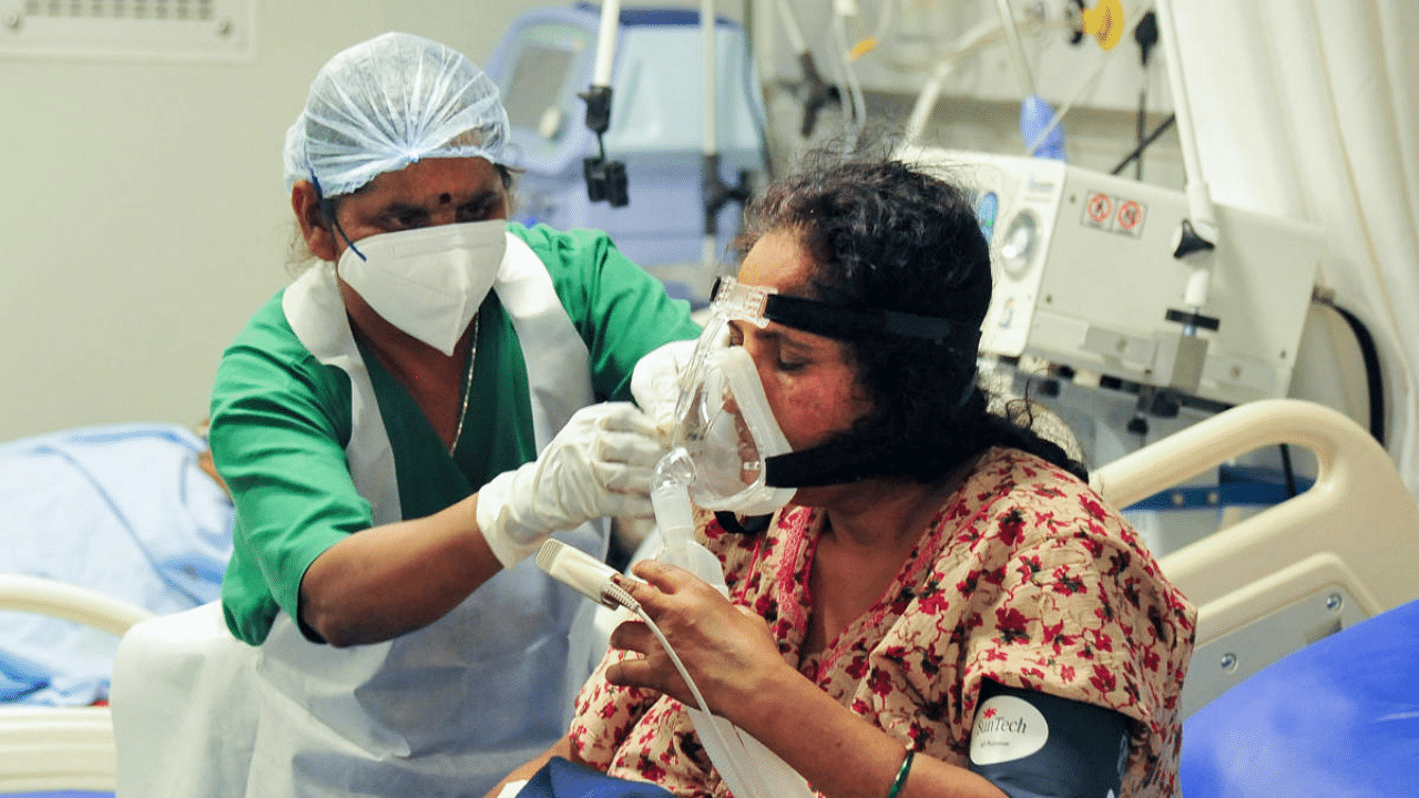 A health worker checks a COVID-19 patient on oxygen support at a hospital, during the second wave of the coronavirus pandemic in Bengaluru. Credit: PTI photo.