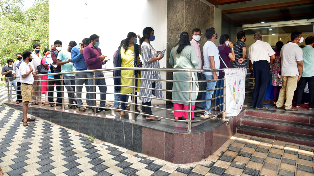 People wait in a queue outside the vaccination centre at Wenlock Hospital in Mangaluru. Credit: DH Photo. 