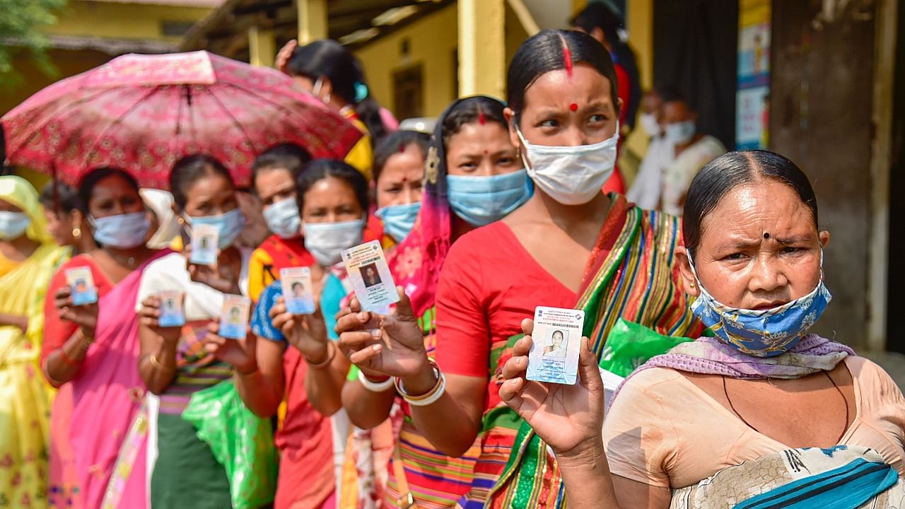 Hajong tribal women show their voter identity cards as they wait in the queue to cast their votes at a polling Station for Assembly polls, at Boko in Kamrup district, Tuesday, April 6, 2021. Credit: PTI Photo