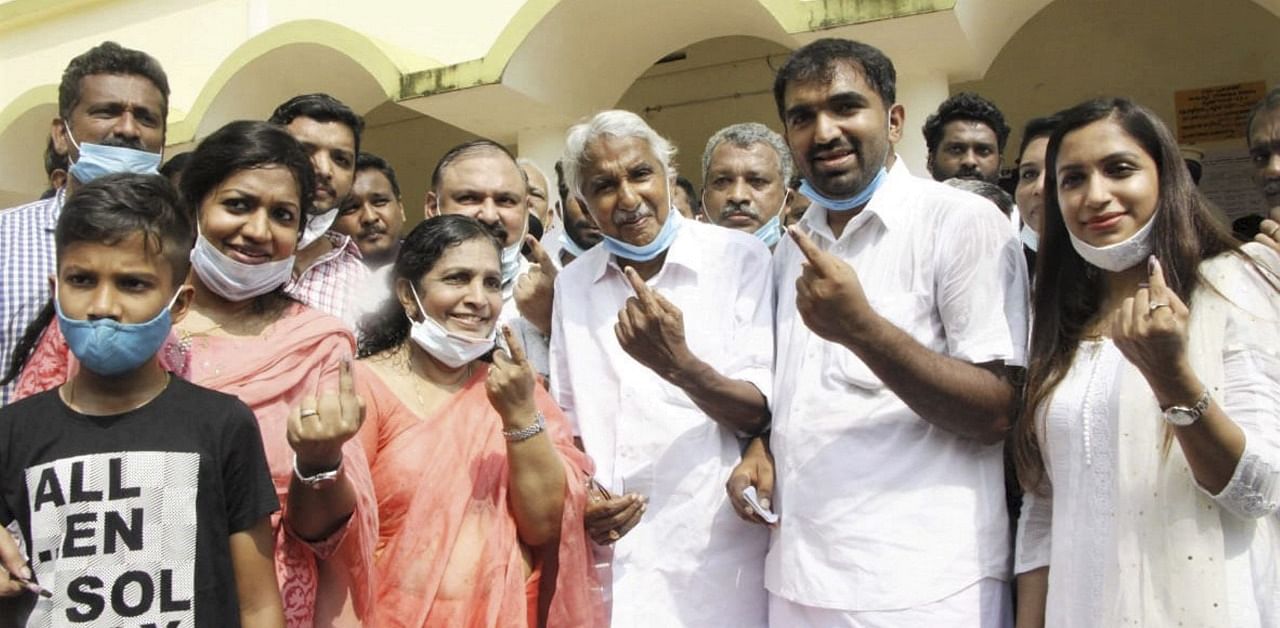 Congress leader Oommen Chandy (C) with his family members after casting their votes in Kerala. Credit: PTI Photo