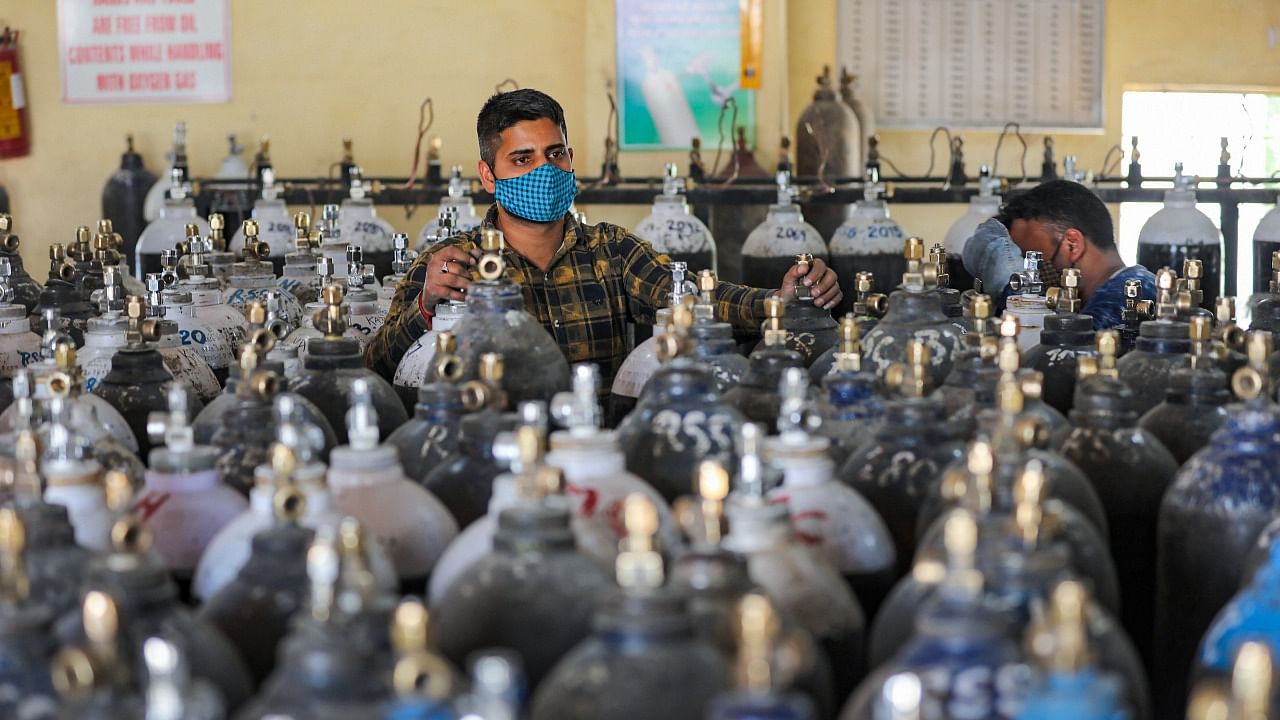 Workers refill cylinders with medical oxygen for supply to various government hospitals for Covid-19 patients, amid a surge in coronavirus cases, in Jammu, Friday, April 23, 2021. Credit: PTI Photo