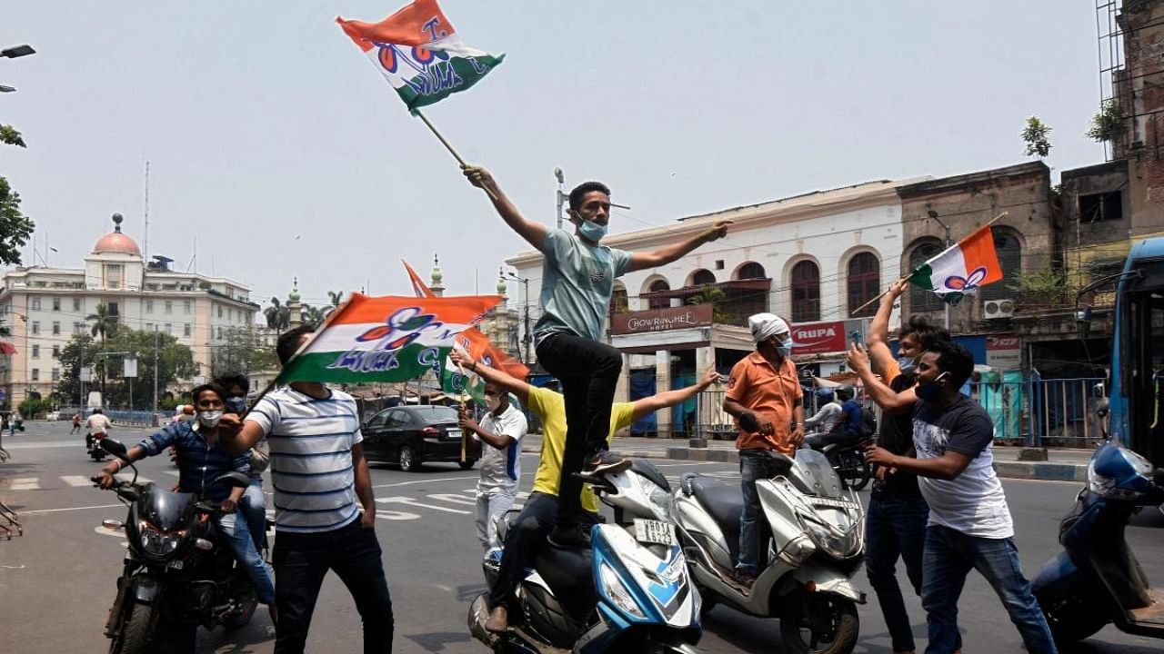 Supporters of Trinamool Congress (TMC) party celebrate their party's lead in the West Bengal state legislative assembly elections during the ongoing counting process in Kolkata. Credit: AFP Photo