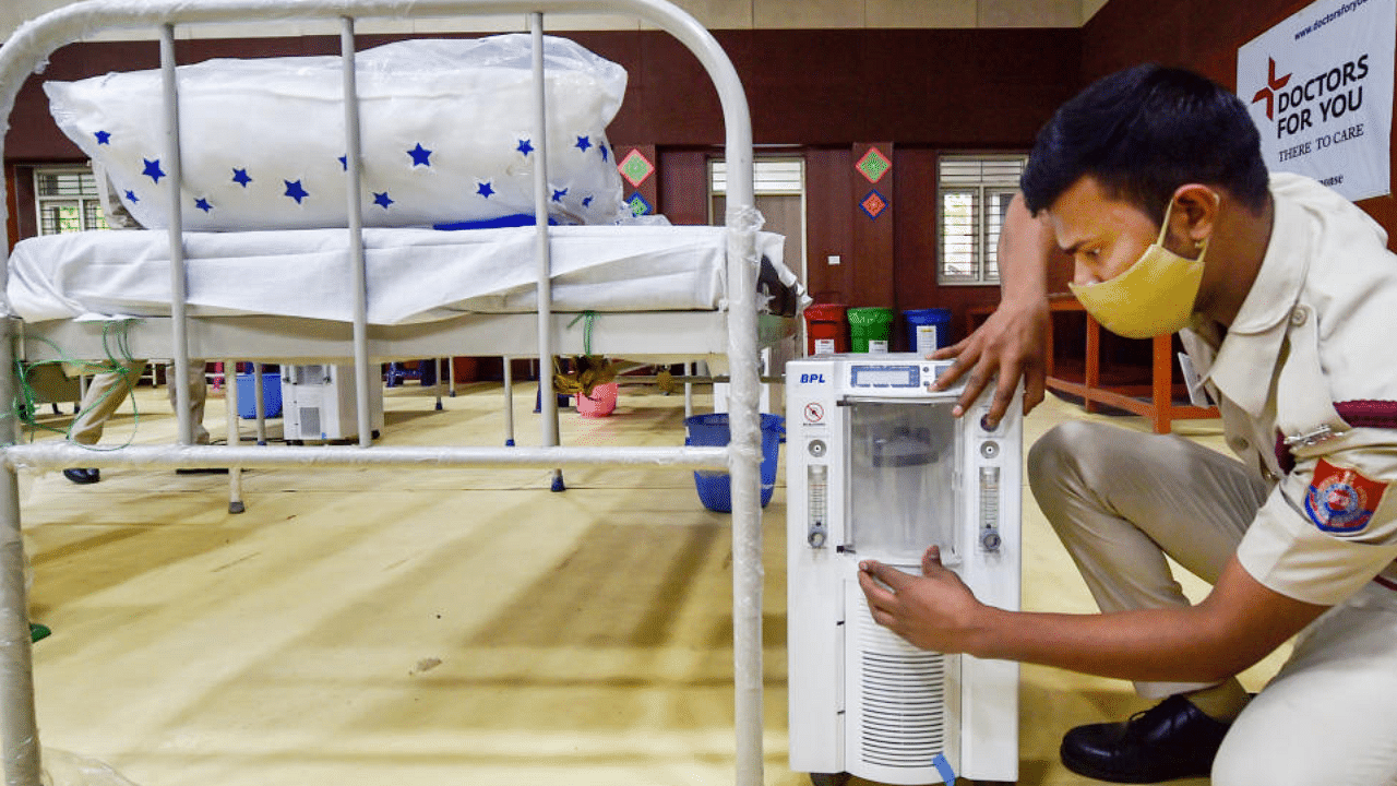 A volunteer prepares beds with oxygen concentrators in New Delhi. PTI file photo