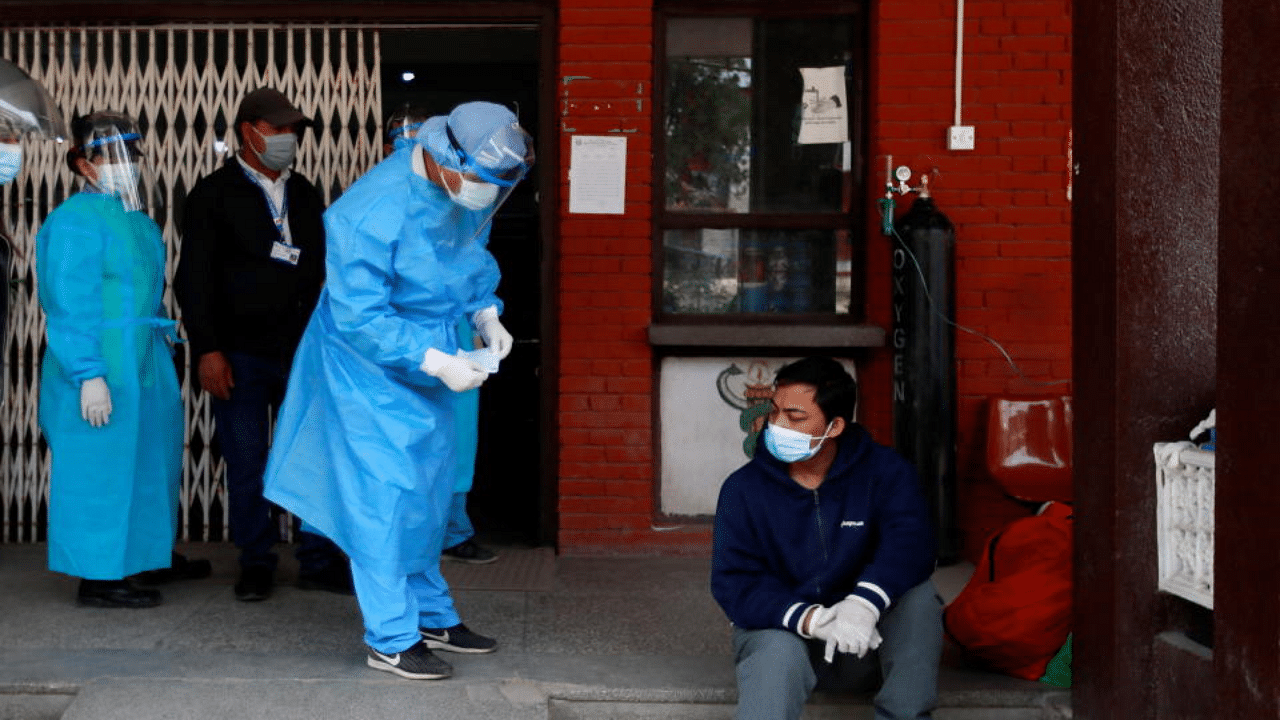 A man suffering from coronavirus disease (COVID-19) sits at the entrance of a hospital while he waits to get admitted amid the lack of free beds at the hospital as the major second coronavirus wave surges in Kathmandu, Nepal April 30, 2021. Credit: Reuters Photo