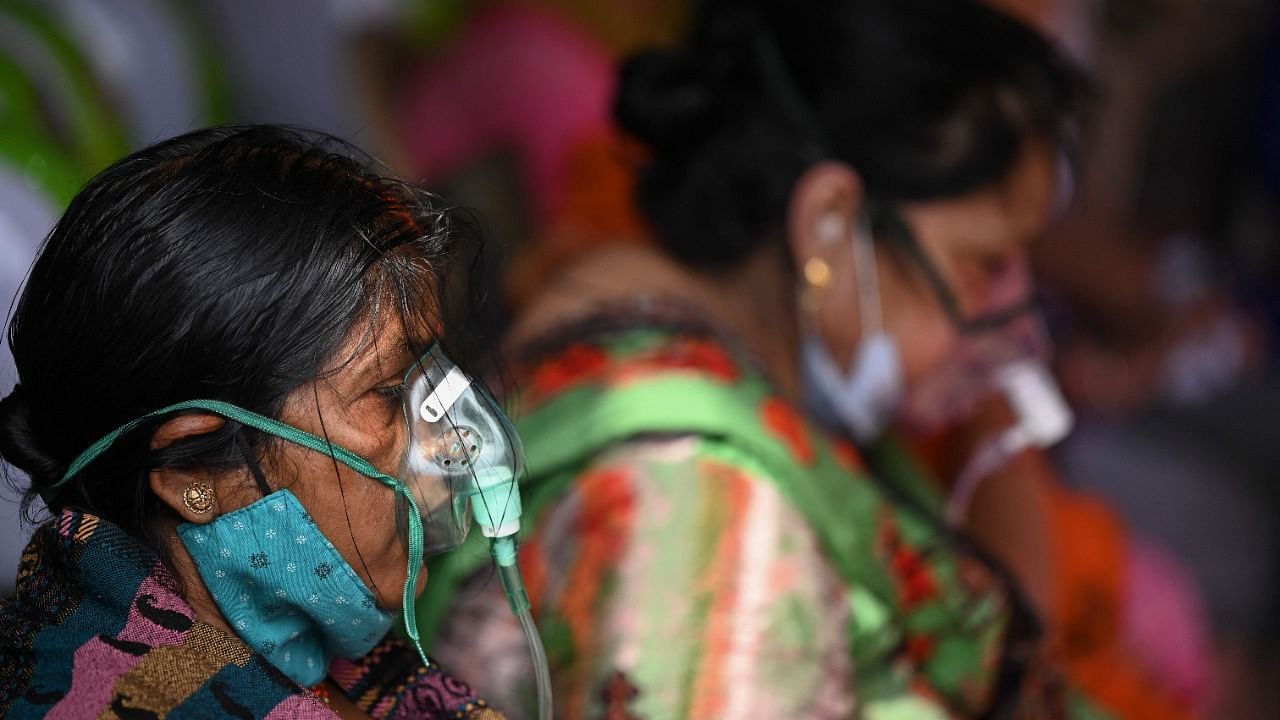 Covid-19 coronavirus patients breath with the help of oxygen provided by a Gurdwara, a place of worship for Sikhs, under a tent installed along the roadside amid Covid-19 coronavirus pandemic in Ghaziabad on May 2, 2021. Credit: AFP Photo