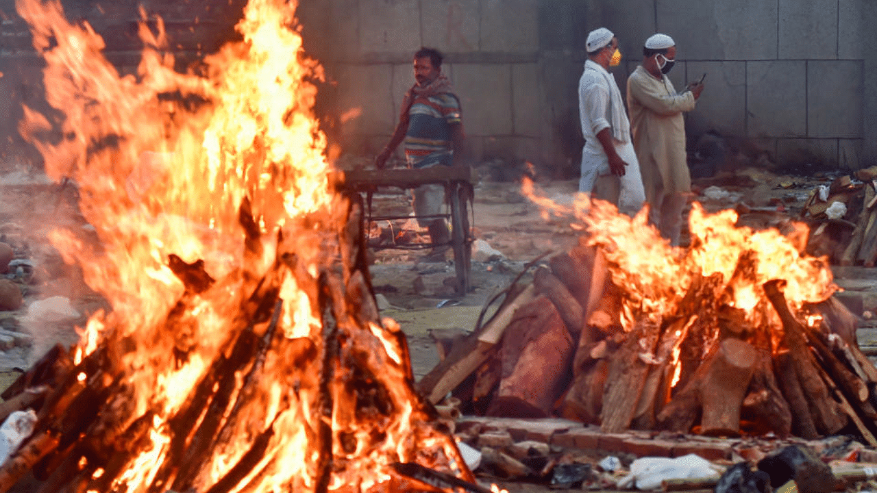  People belonging to Muslim community help in cremation of their friend's relative who died at his residence, at Old Seemapuri Cremation Grounds in New Delhi , Sunday, May 2, 2021. credit: PTI Photo