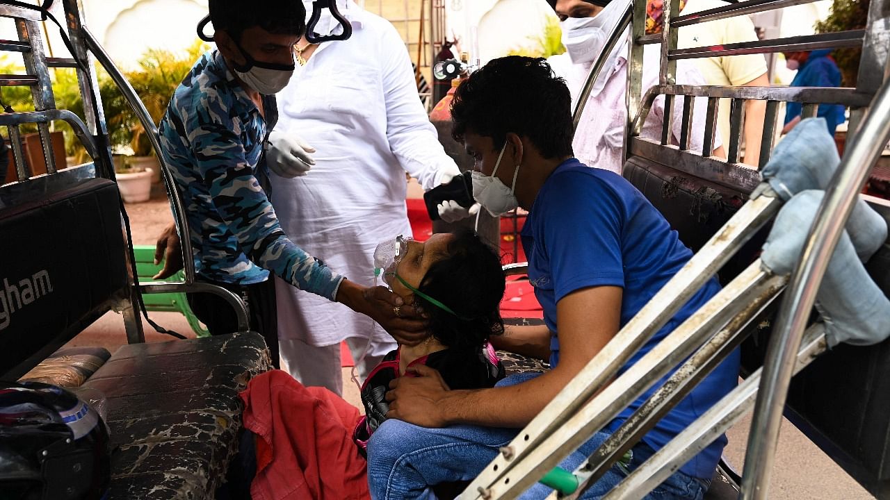 A patient struggles to breathes with the help of oxygen provided by a gurudwara under a tent installed along a roadside amid the Covid-19 coronavirus pandemic in Ghaziabad. Credit: AFP photo