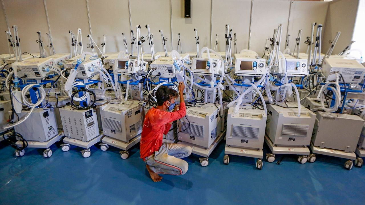 A worker checks ventilators inside the 900 bed Covid-19 hospital at Convention Center, which has been converted into Covid care cente in Ahmedabad. Credit: PTI Photo