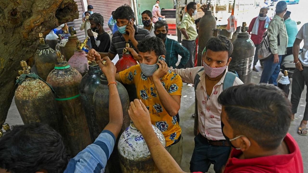 People wait to refill their medical oxygen cylinders for the Covid-19 coronavirus patients under home quarantine. Credit: AFP Photo