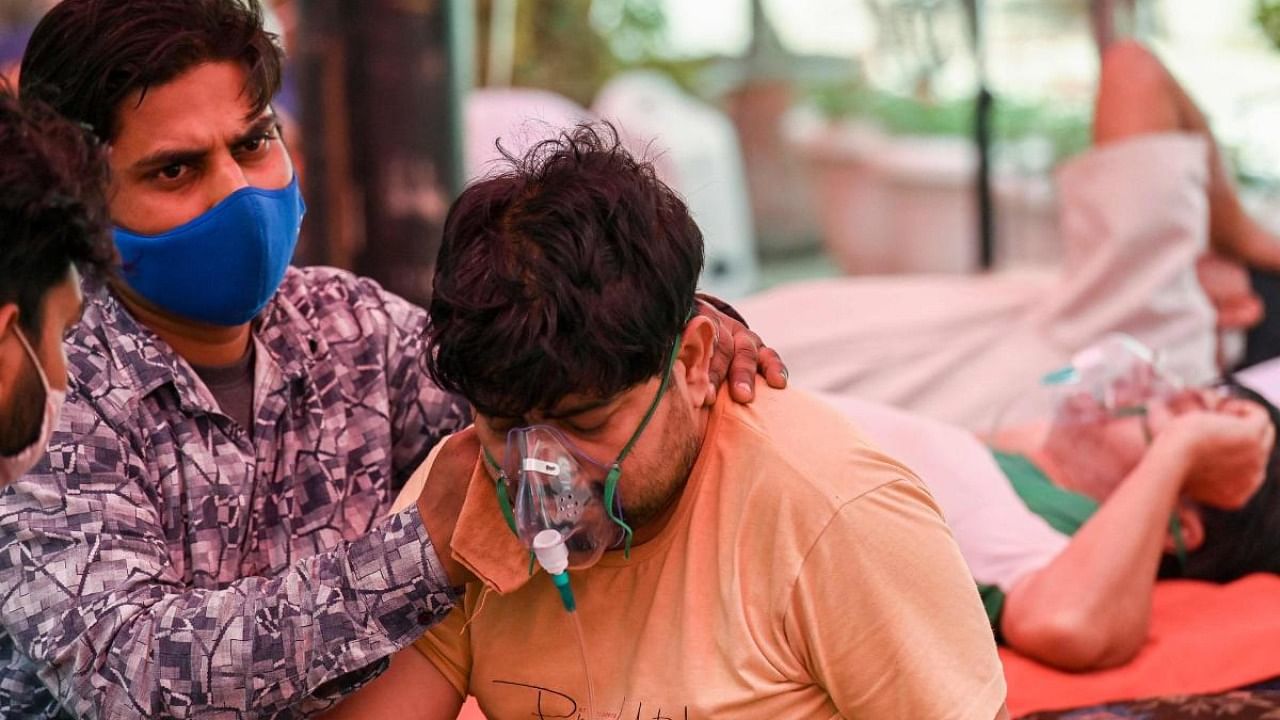 A Covid-19 patient breathes using oxygen. Credit: AFP Photo