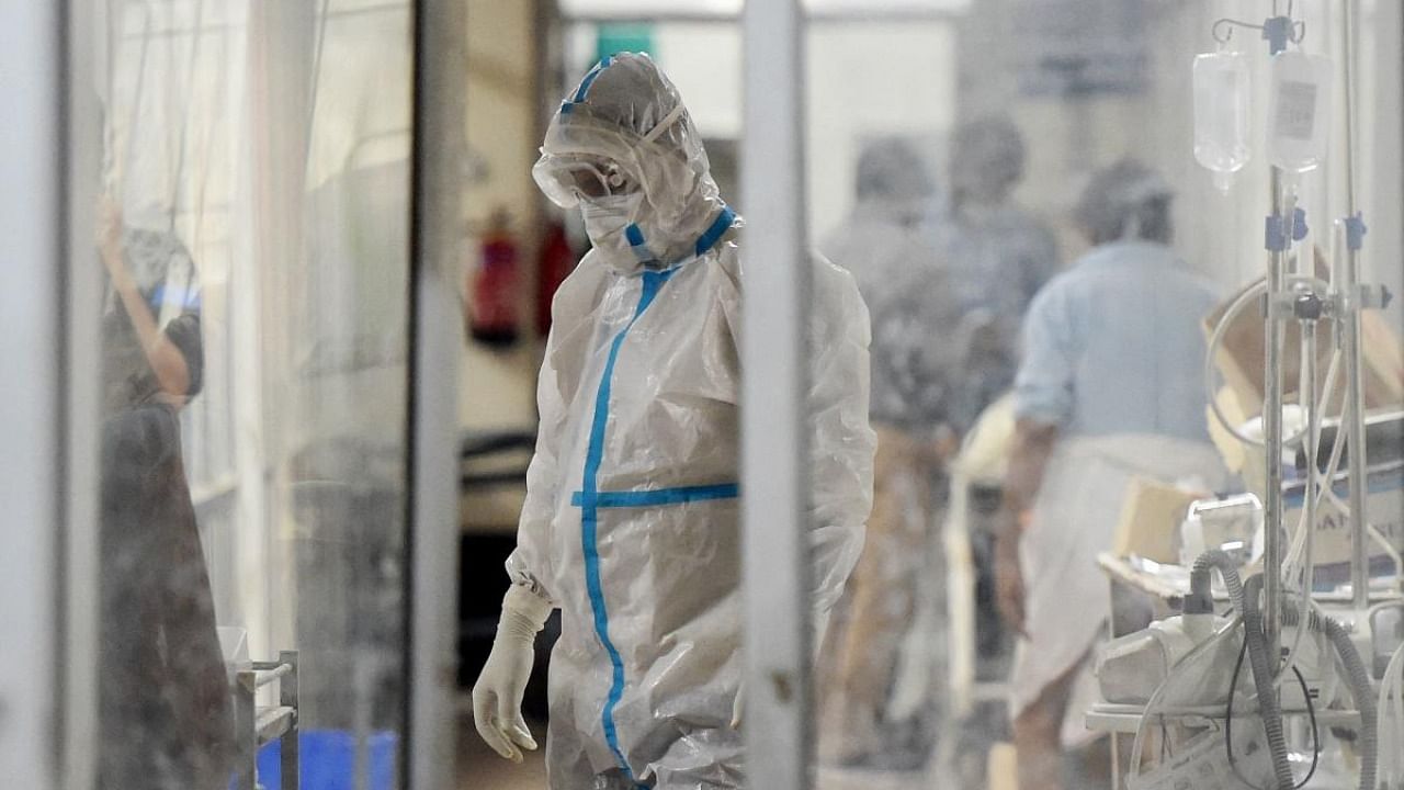 A health worker wearing a personal protective equipment (PPE) suits attends a Covid-19 coronavirus patient inside a Covid-19 ward at the SRN hospital, in Allahabad. Credit: AFP Photo