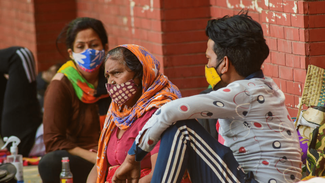 Relatives of Covid-19 patients admitted at LNJP hospital, rest on a pavement outside, as coronavirus cases surge, in New Delhi, Wednesday, May 5, 2021. Credit: PTI Photo