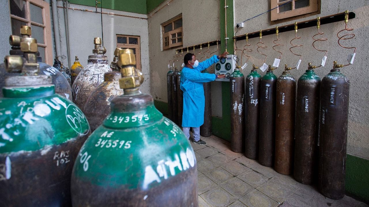 A health worker refills empty oxygen cylinders at a Covid-19 care centre established by District Disaster Management Authorities (DDMA) in Srinagar. Credit: AFP photo