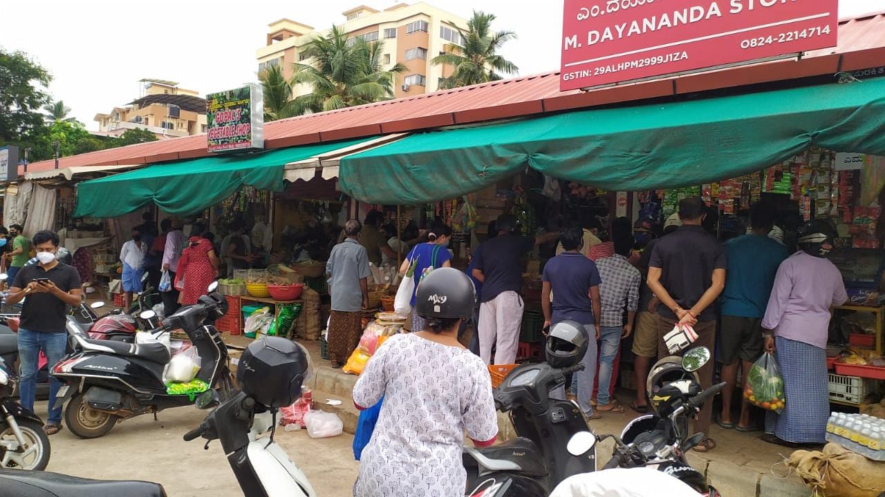 People queue up outside vegetable shops at Mallikatte market in Mangaluru on Friday. Credit: DH Photo/Govindraj Javali