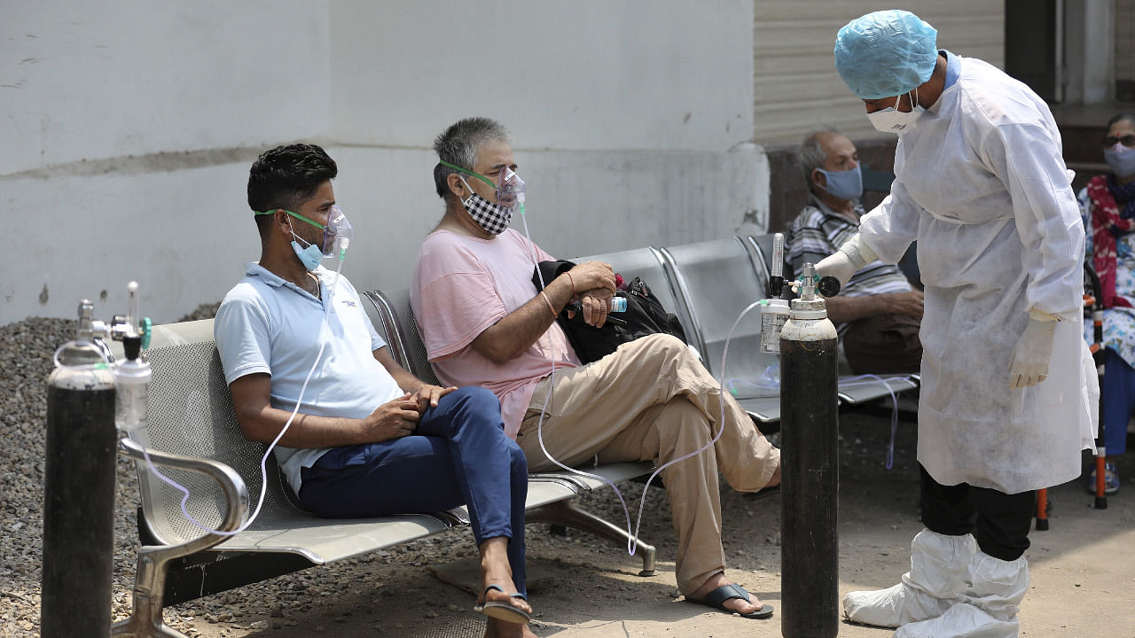 Patients, on oxygen support, wait outside the Covid-19 facility of the Chest Disease Hospital, in Jammu. Credit: PTI Photo