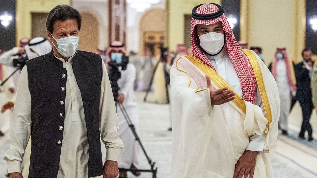 A handout picture provided by the Saudi Royal Palace on May 8, 2021, shows Saudi Crown Prince Mohammed bin Salman (R), welcoming Pakistan's Prime Minister Imran Khan, in Saudi Arabia's Red Sea city of Jeddah. Credit: AFP Photo