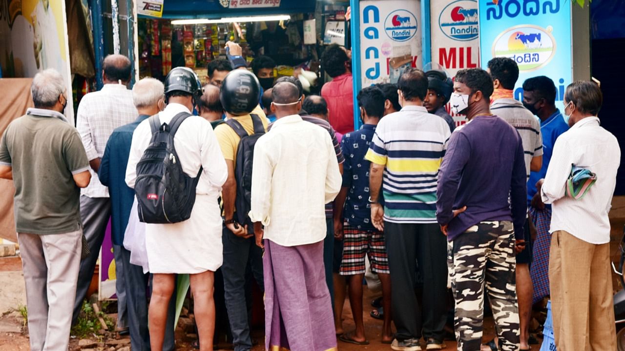 People forgot social distance while purchasing milk at a milk booth in Urwastore in Mangaluru. Credit: DH Photo/Govindraj Javali