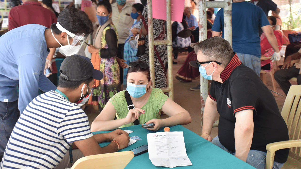 A foreign couple enquire for Covid-19 vaccine at the KC General hospital in Bengaluru. Credit: DH photo/Janardhan B K