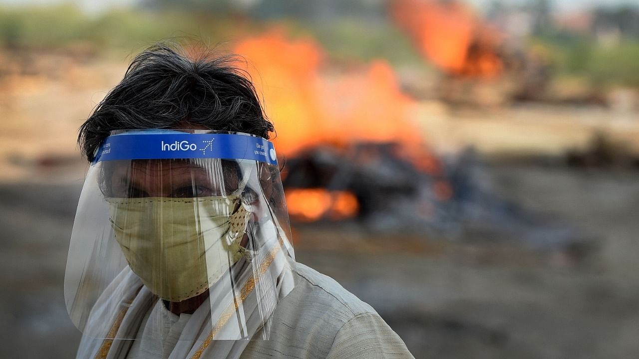 A family member stands near the funeral pyre of his loved one who died due to the Covid-19 coronavirus at a cremation ground in Allahabad on May 8, 2021, as India recorded more than 4,000 coronavirus deaths in a day for the first time. Credit: AFP Photo