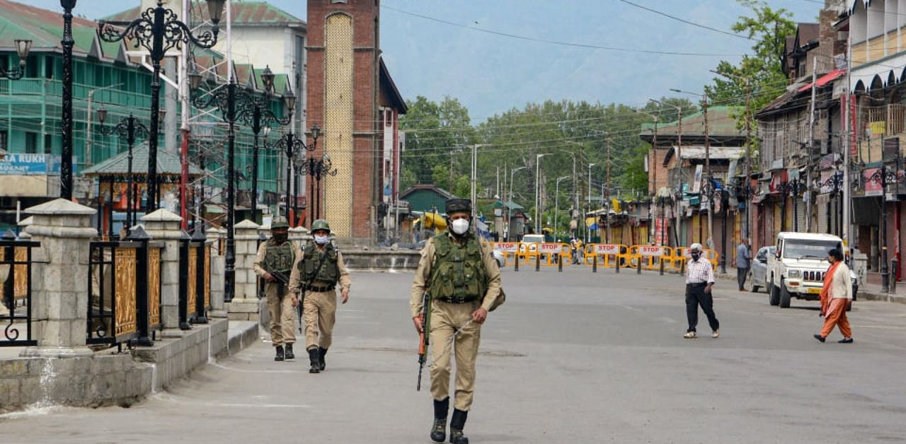 Security personnel patrol on a deserted street during Covid-induced curfew in Srinagar, Saturday, May 8, 2021. Credit: PTI Photo
