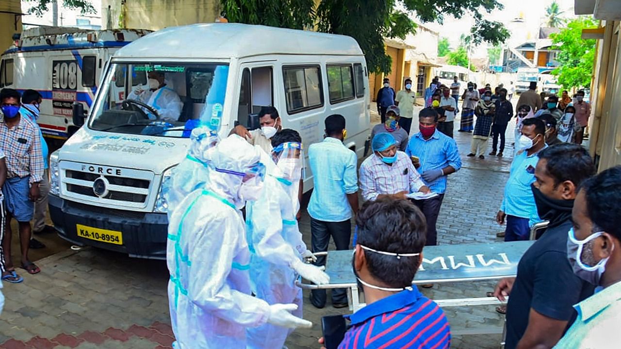 Medics and relatives after 24 Covid- 19 patients died, allegedly due to shortage of oxygen cylinders, in Chamarajanagara District of Karnataka. Credit: PTI Photo