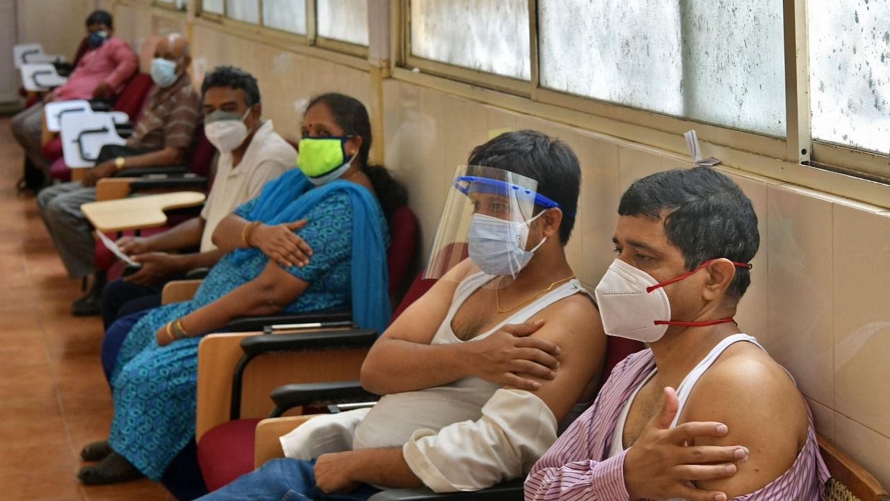 People sit in an observation room after getting a dose of the Covaxin Covid-19 vaccine at a vaccination centre in KC General government hospital in Bengaluru. Credit: AFP Photo