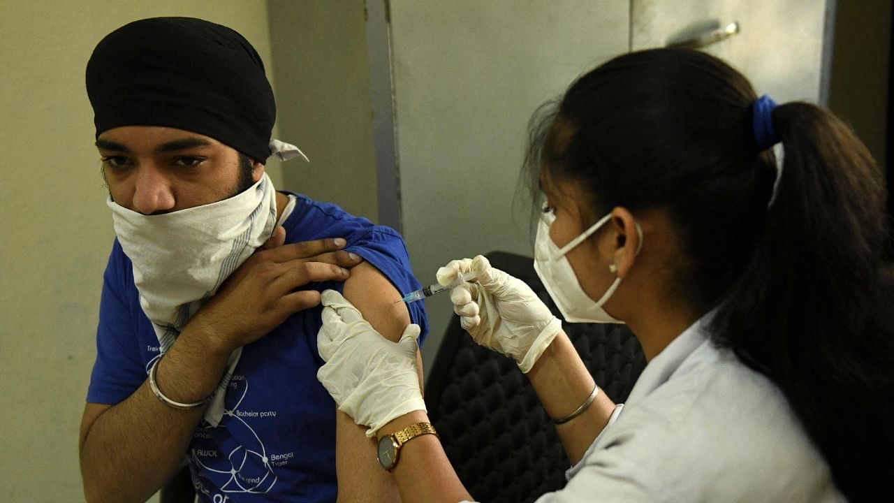 A medical worker inoculates a man with a dose of the Covishield vaccine against the Covid-19 coronavirus at a health centre in Amritsar on May 10, 2021. Credit: AFP Photo