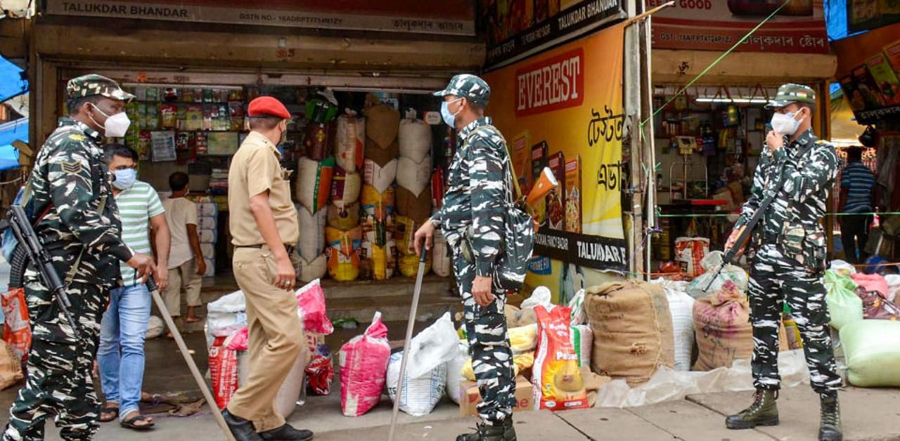 Security personnel request vendors to close their shops as part of COVID-induced restrictions due to a surge in coronavirus cases, at Fancy Bazar in Guwahati. Credit: PTI Photo