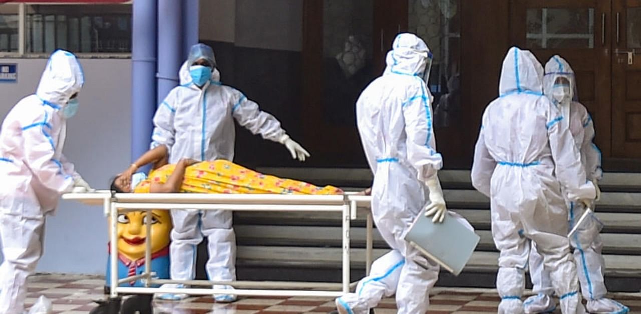 Health workers wearing PPE suit, admit a Covid patient amid the pandemic, at a state government-run Covid hospital in Kolkata. Credit: PTI Photo