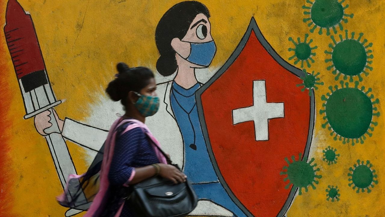 A woman walks past a graffiti on a street, amidst the spread of the coronavirus in Mumbai, India, May 10, 2021. Credit: Reuters Photo
