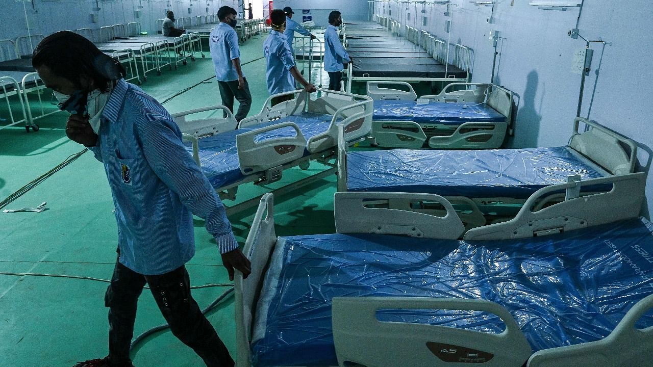 Volunteers arrange beds for patients at the Ramleela Maidan ground temporarily converted into a Covid-19 coronavirus care centre, in New Delhi. Credit: AFP Photo