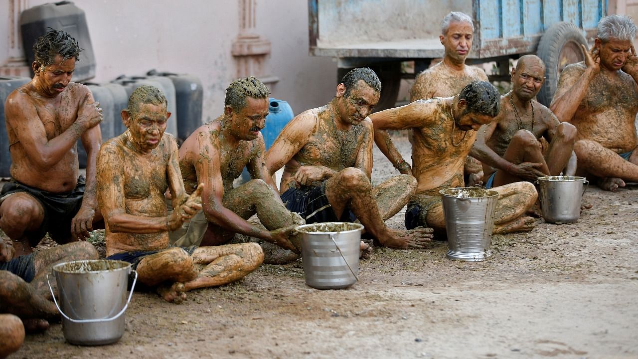 People apply cow dung on their bodies during "cow dung therapy" on outskirts of Ahmedabad. Credit: Reuters photo