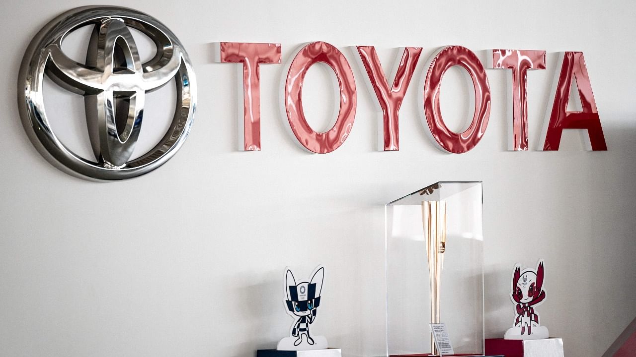 This picture shows a Toyota logo next to the Tokyo 2020 Olympic and Paralympic Games mascots and torch at a closed Toyota showroom in Tokyo on May 12, 2021. Credit: AFP Photo