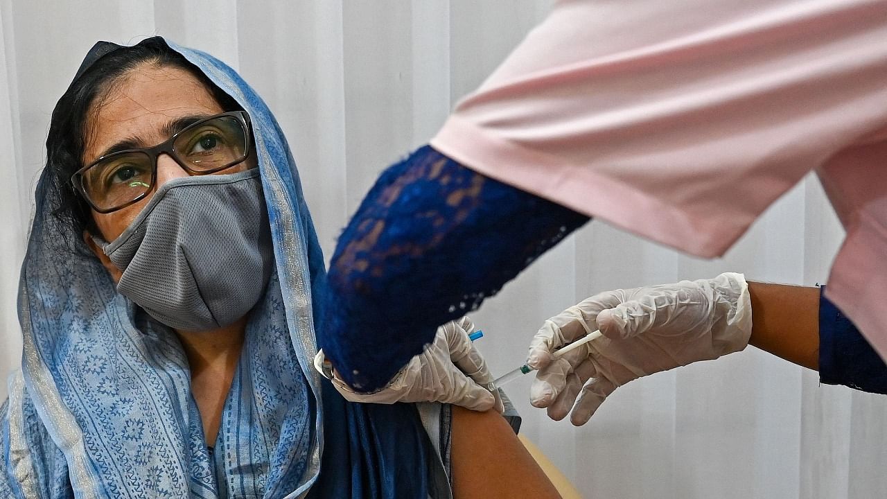 A woman gets inoculated with the Covid-19 coronavirus vaccine at a vaccination center in Mumbai on May 12, 2021. Credit: AFP Photo