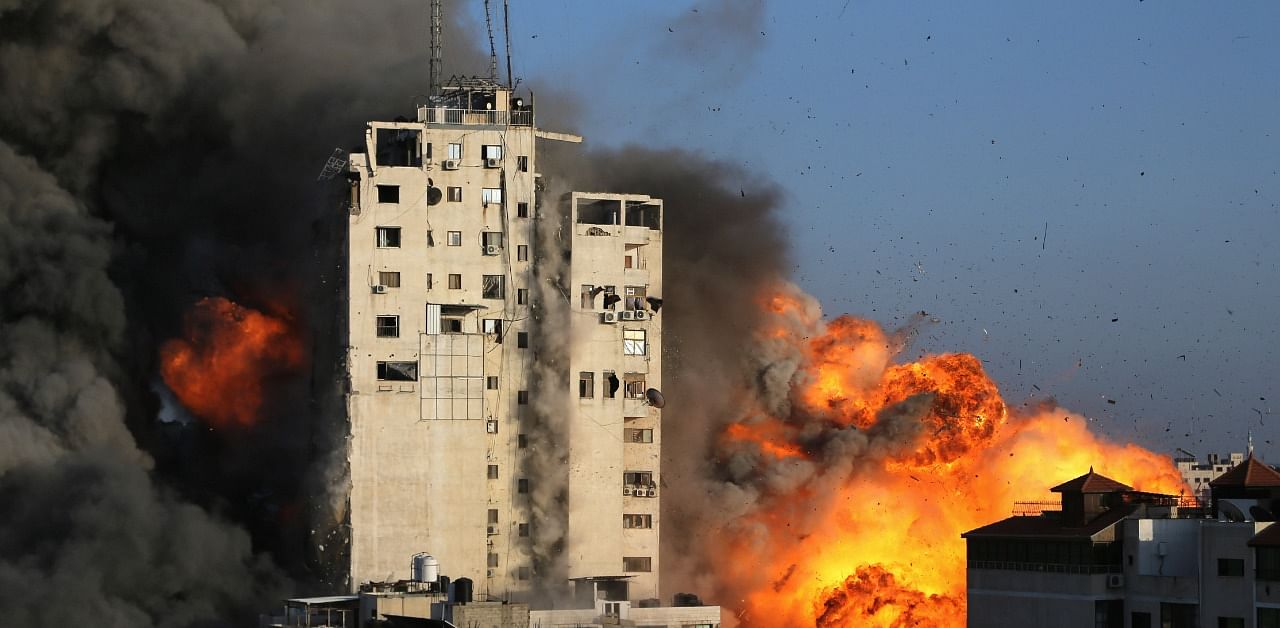 Flames rise from a tower building as it is destroyed by Israeli air strikes. Credit: Reuters Photo
