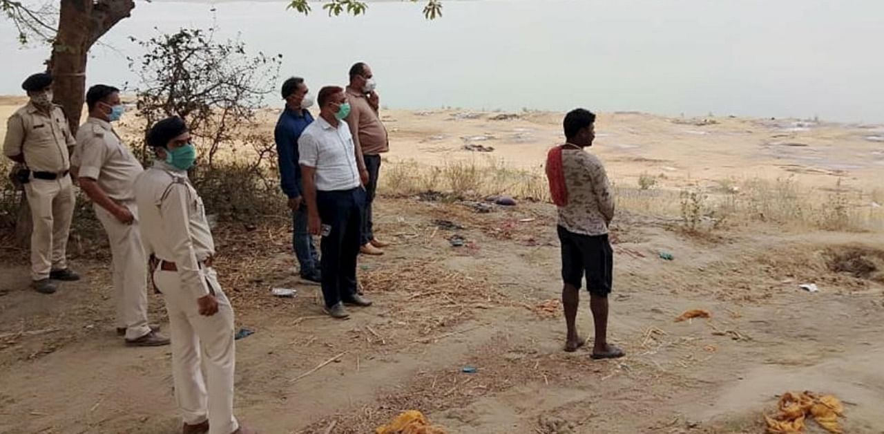 Police personnel inspecting buried bodies found at Mahadev Ghat on the banks of river Ganga in Chausa village, in Buxar, Tuesday, May. 11,2021. Credit: PTI Photo